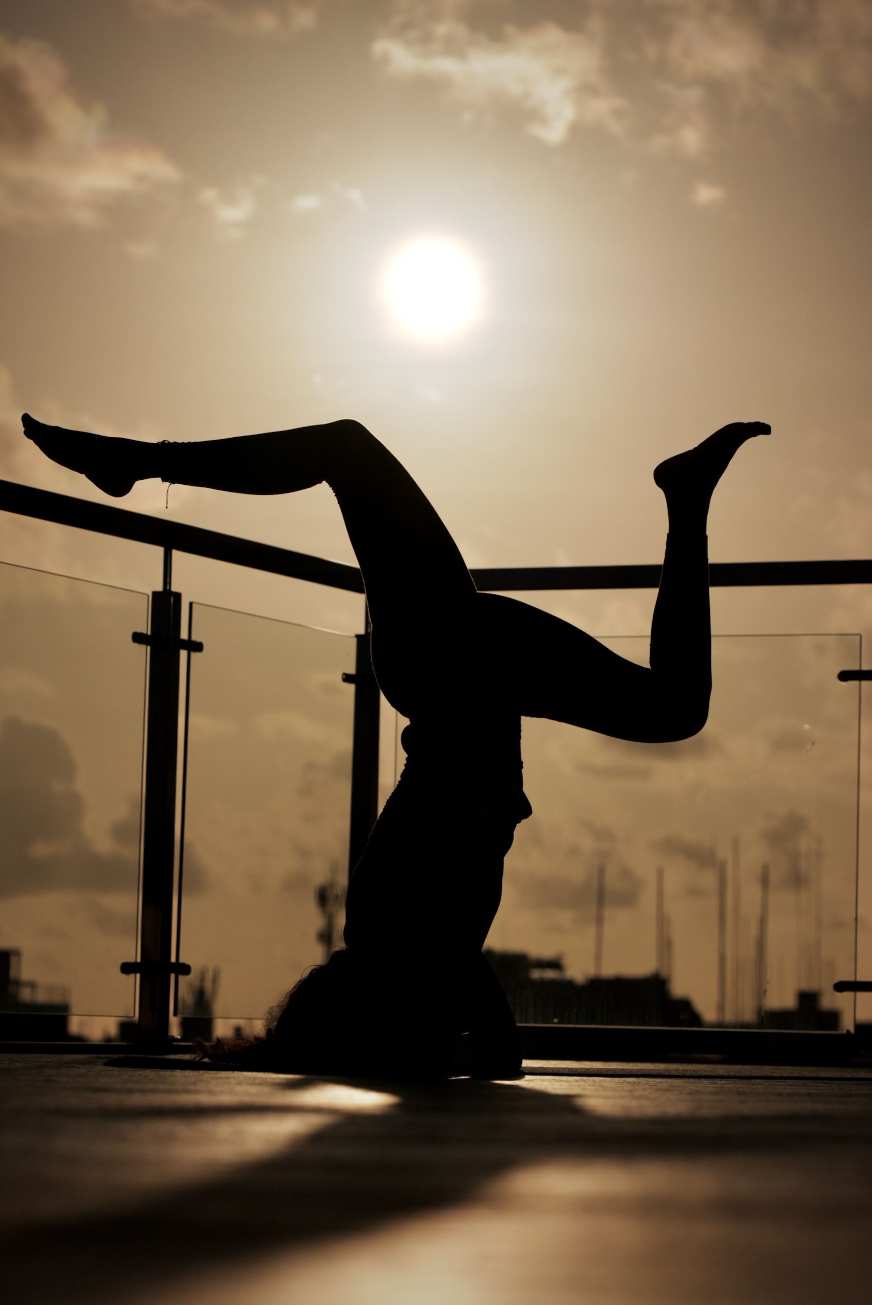 Zey in headstand silhouette, rooftop at sunset